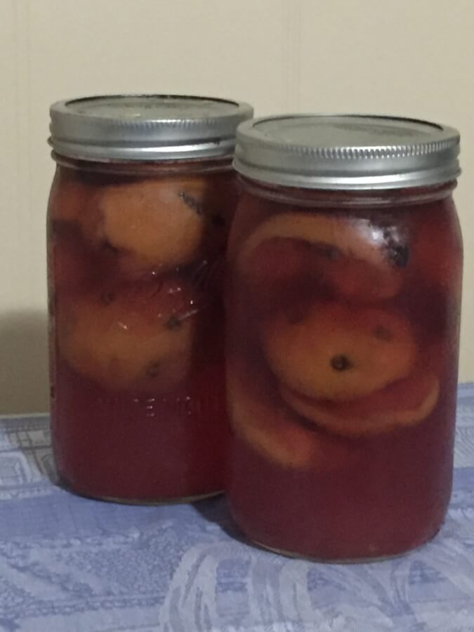Glass jars of pickled peaches.