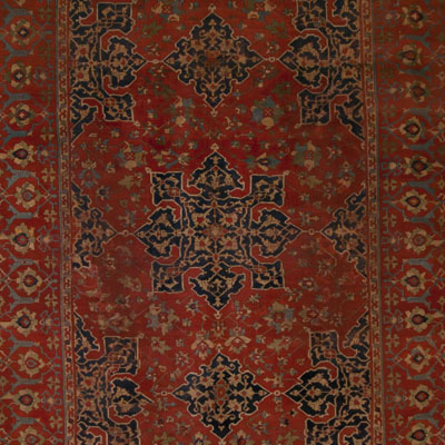Primer plano de una alfombra con dibujos rojos.