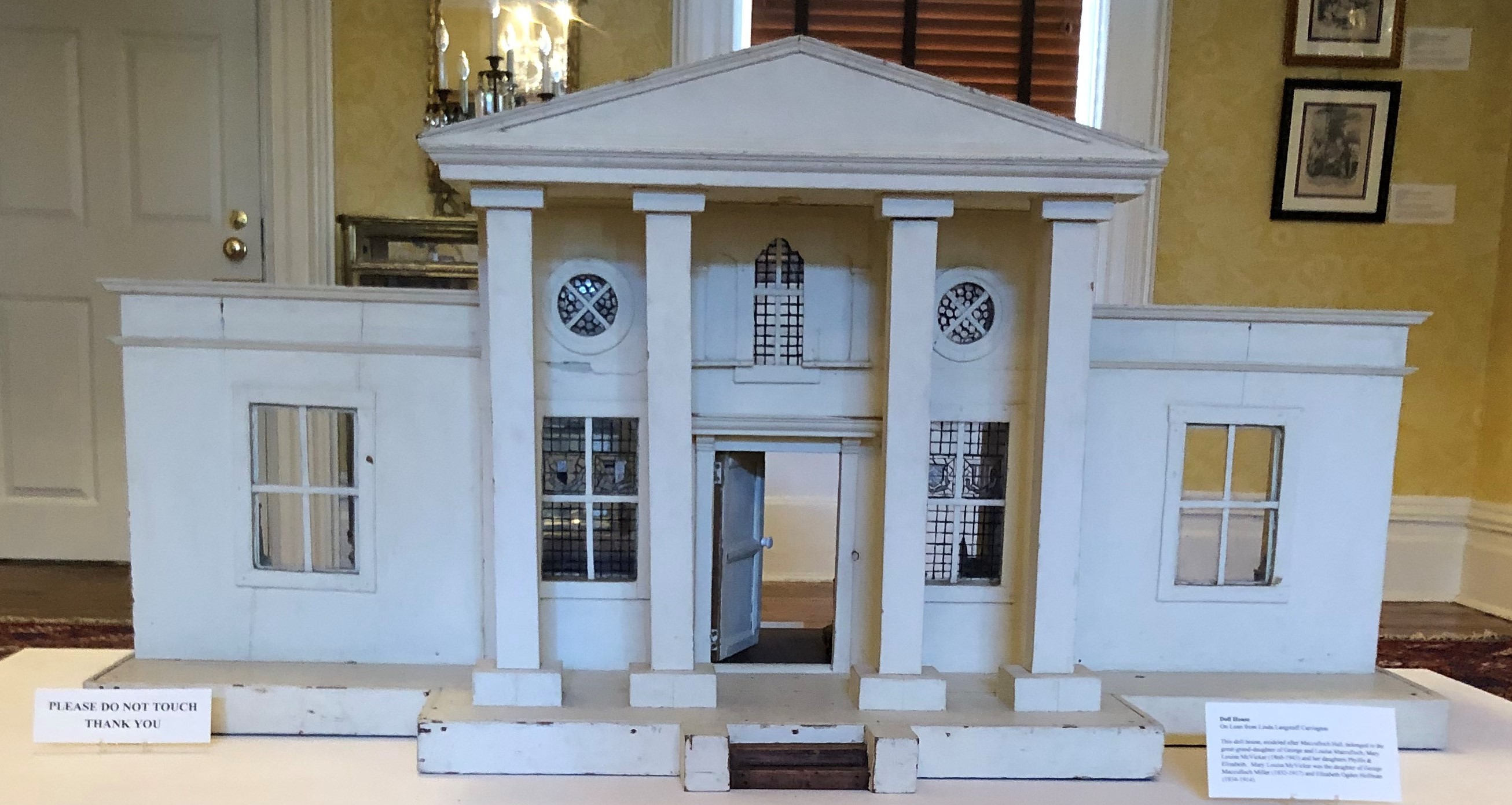Exterior of a white dollhouse, made to look like Macculloch Hall.