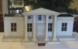 Front side of a white dollhouse.