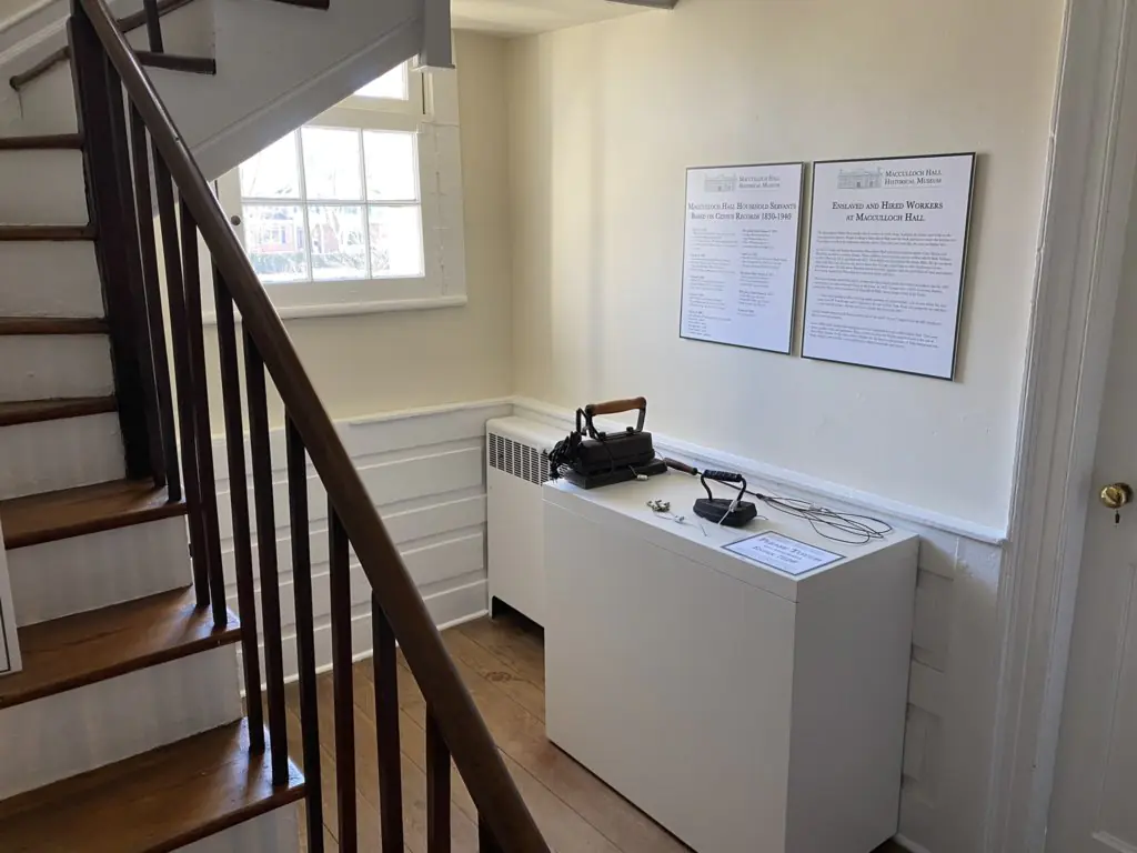 A staircase is on the left hand side of the image. Behind the staircase is a display of objects that can be touched and information panels.