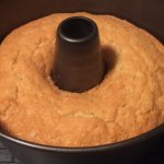 Un pastel redondo horneado en un molde. El molde tiene un centro, creando un agujero en el pastel.