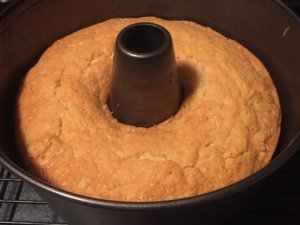 A round baked cake in a tin. The tin has a center, creating a hole in the cake.