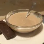 Chocolate jelly-pudding2 A bowl of chocolate jelly with spoon sits next to bars of chocolate on a white plate.