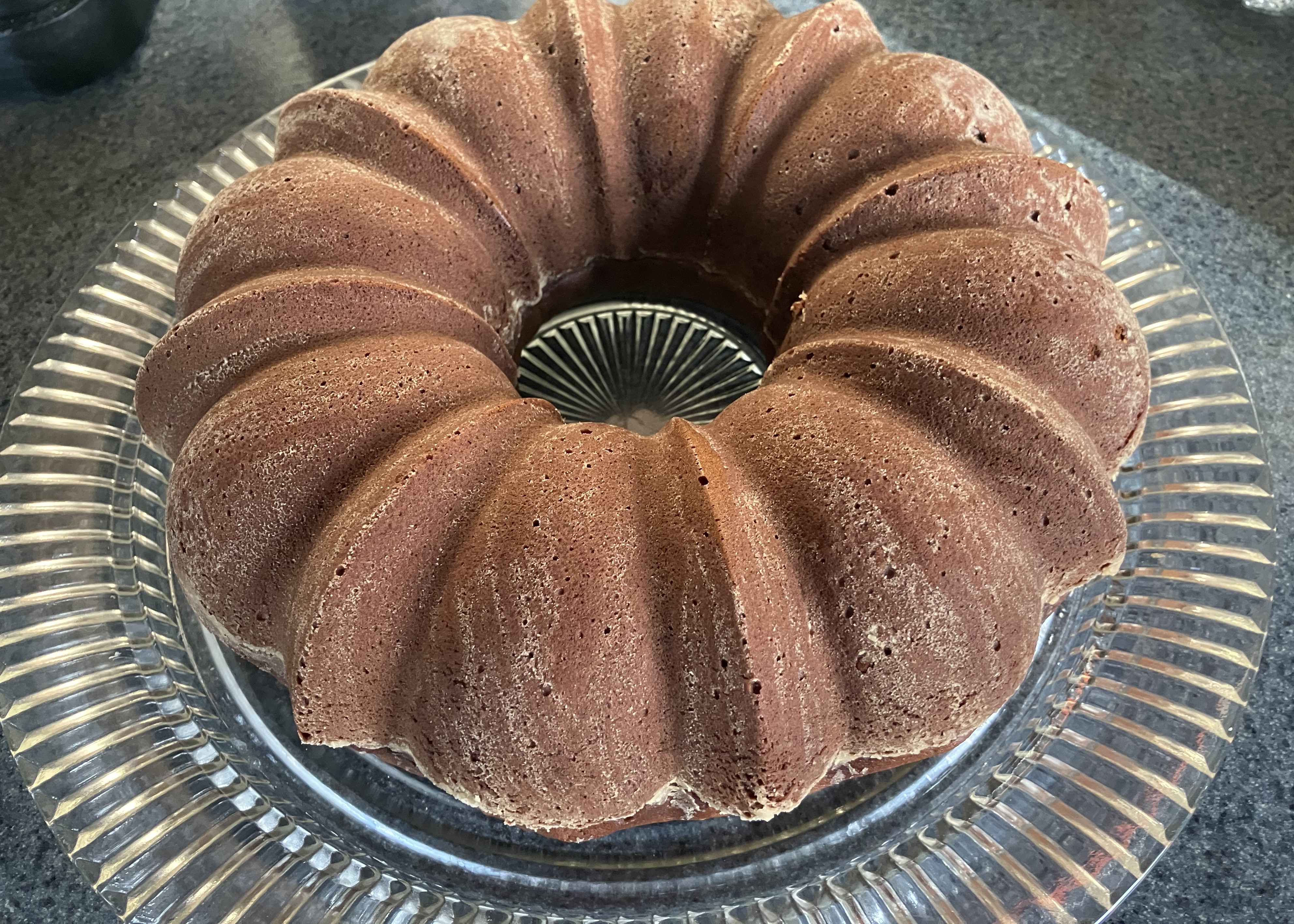A round, baked cake that was shaped by a decorative bundt pan.