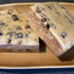 Two square slices of Nameless cake with raisins.