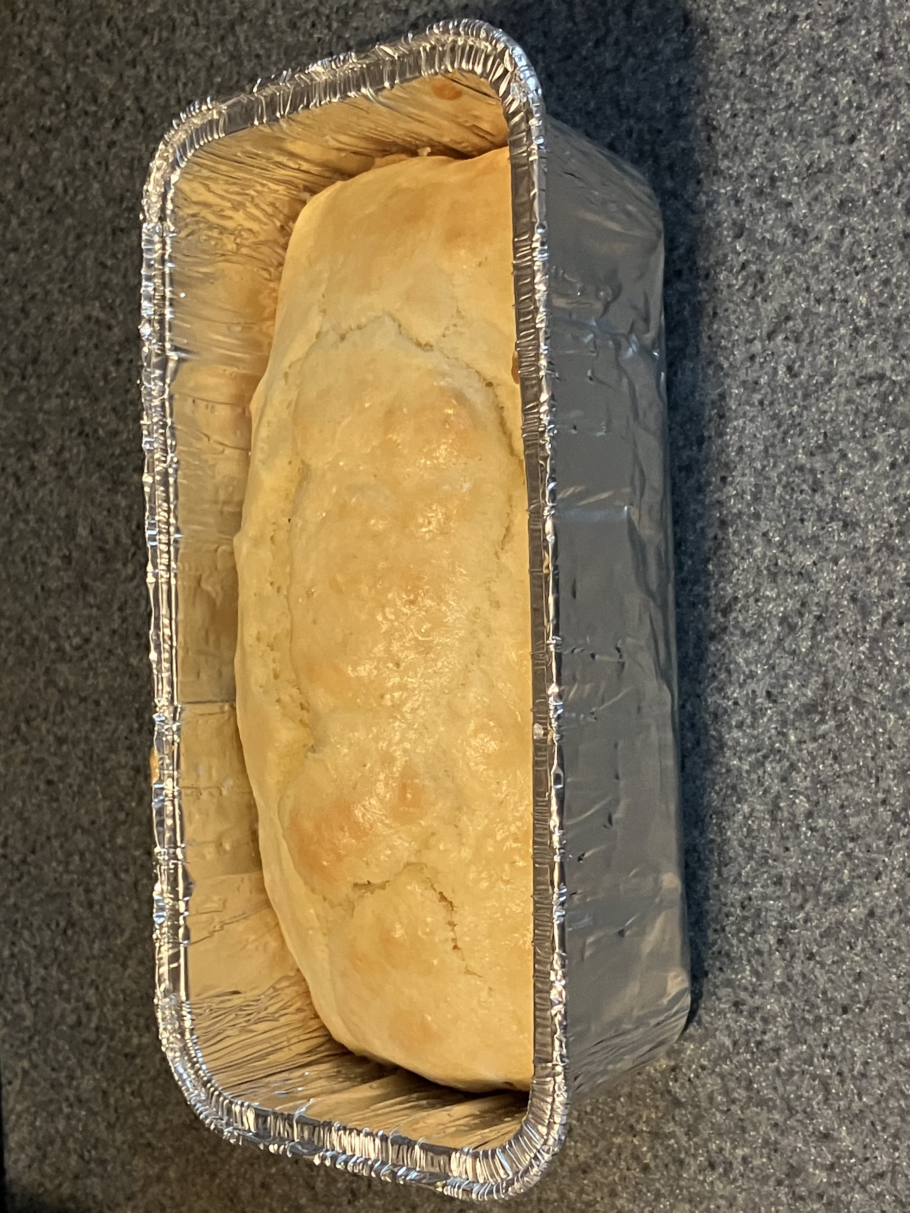 A baked loaf of cake in a metal pan.