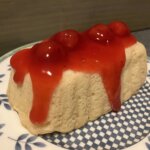 Baked rectangular tea cake with cherry preserves and sauce on top.