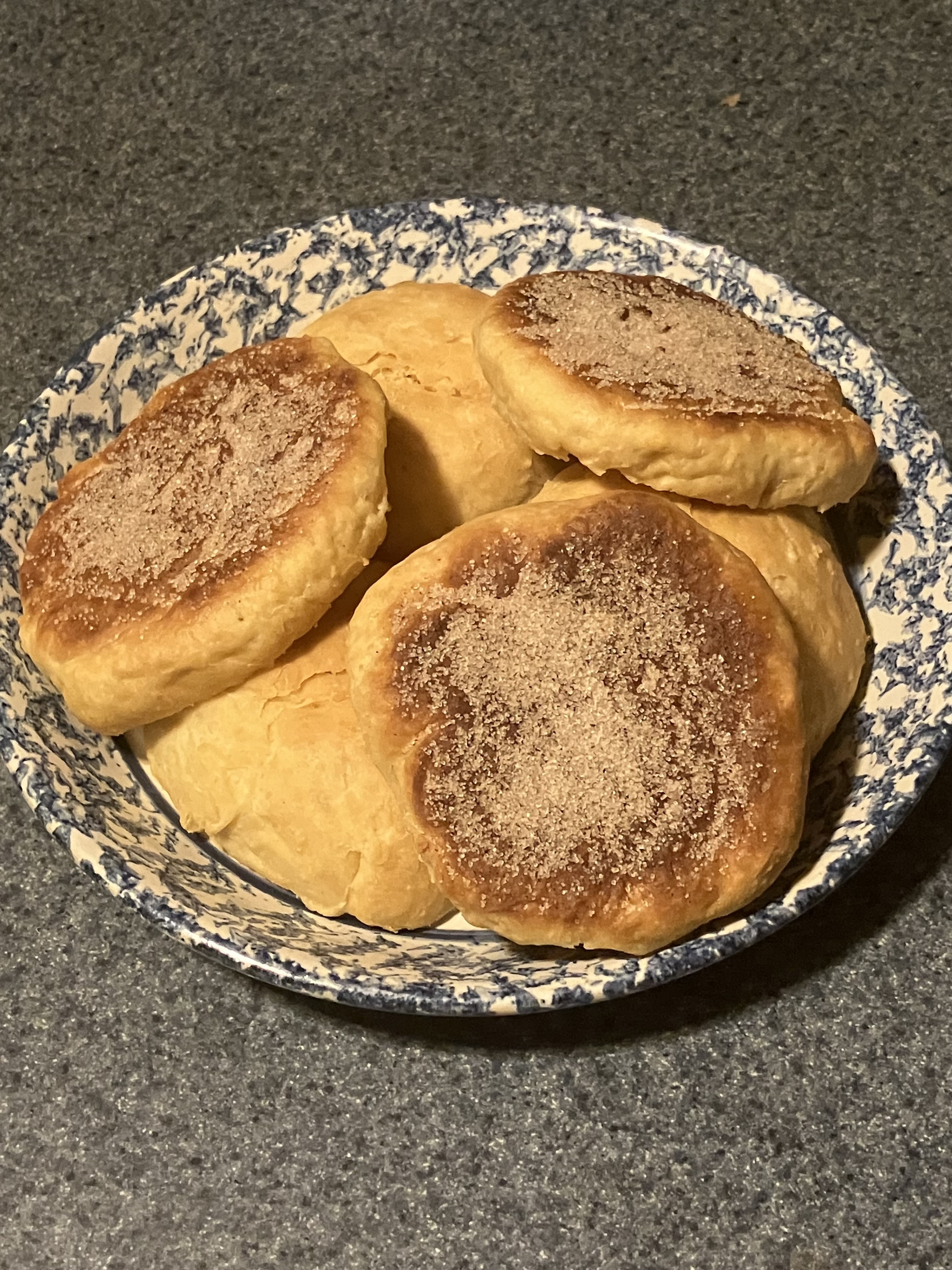 Baked rusk rounds stacked on a blue and white plate.