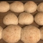 Baked round rusk rolls on a baking sheet.