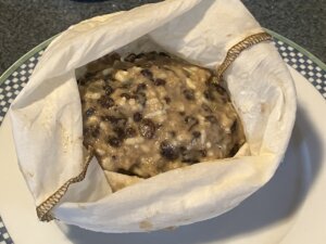 Plum pudding batter in a white pudding bag.